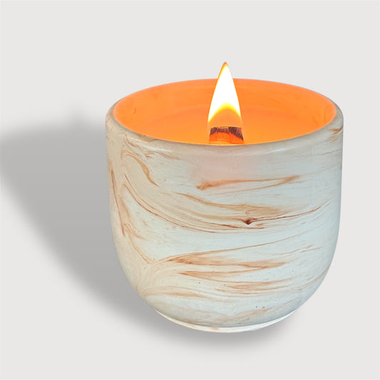 Candle in a marbled ceramic holder with a white background